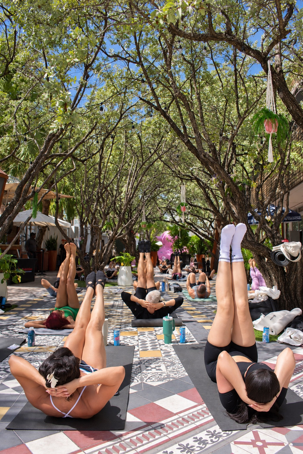 Participants exercising on mats beneath the trees at a Total Nutrition community event.